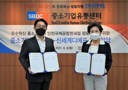 지난 6일 서울 목동 소재 중소기업유통센터에서 열린 '신세계면세점-중소기업유통센터 업무협약식'에서 문현규 신세계디에프 상무(왼쪽)와 이시희 중소기업유통센터 마케팅판로본부장이 기념촬영을 하고 있다. 신세계면세점 제공